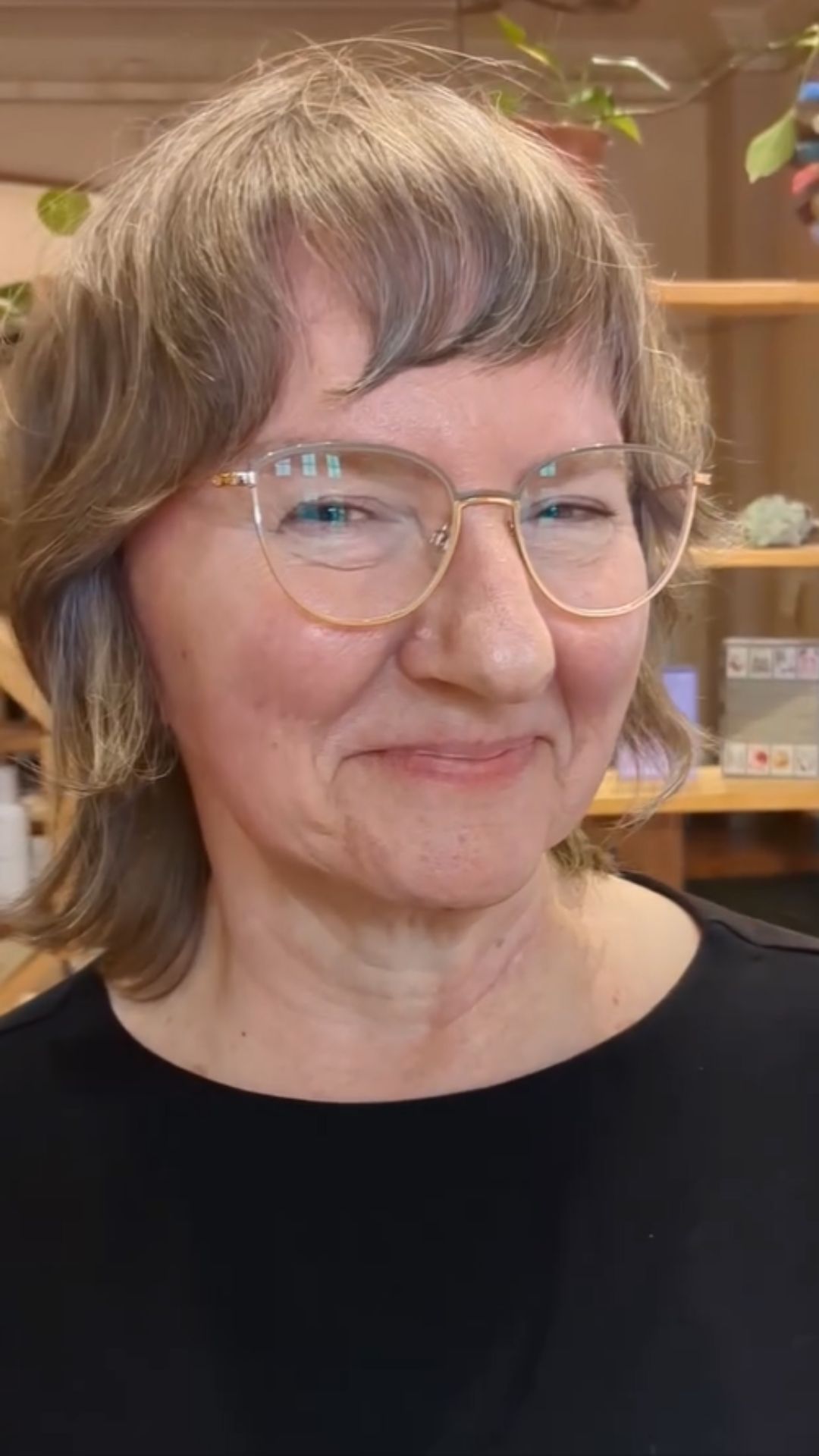 An older woman with glasses modelling a short shag hairstyle.