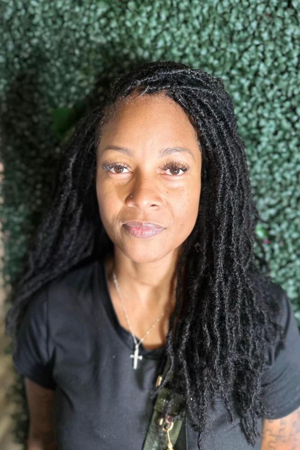 A woman with side-parted layered sisterlocks.