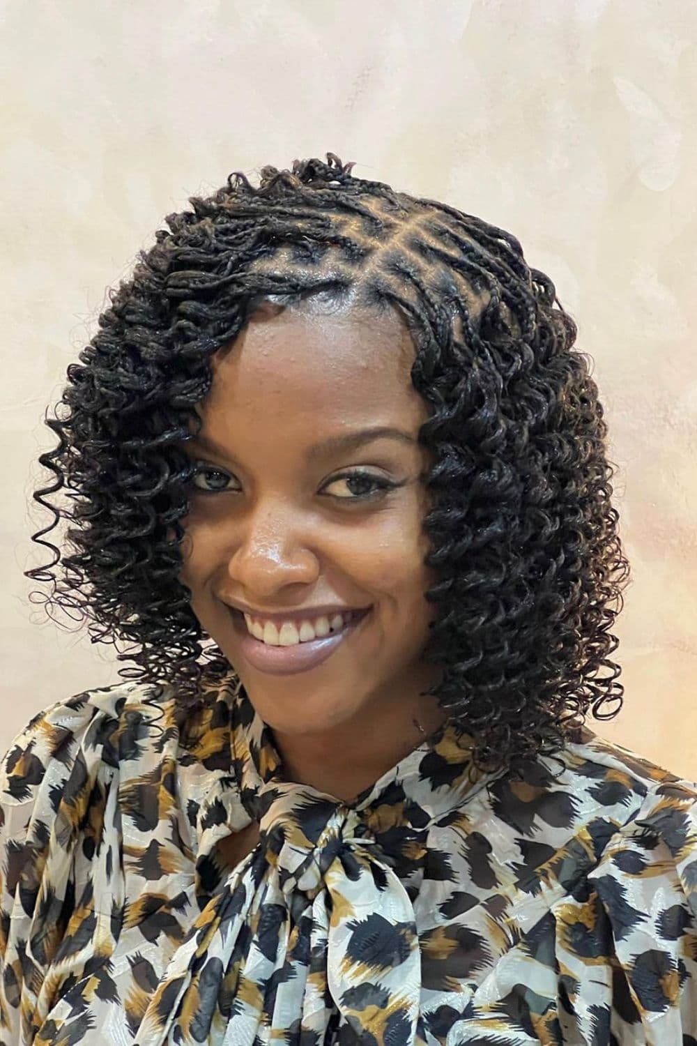 A woman with a black side-parted twists with curls.