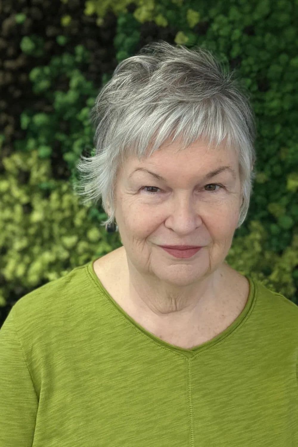 A woman with a short gray side-swept feather cut.