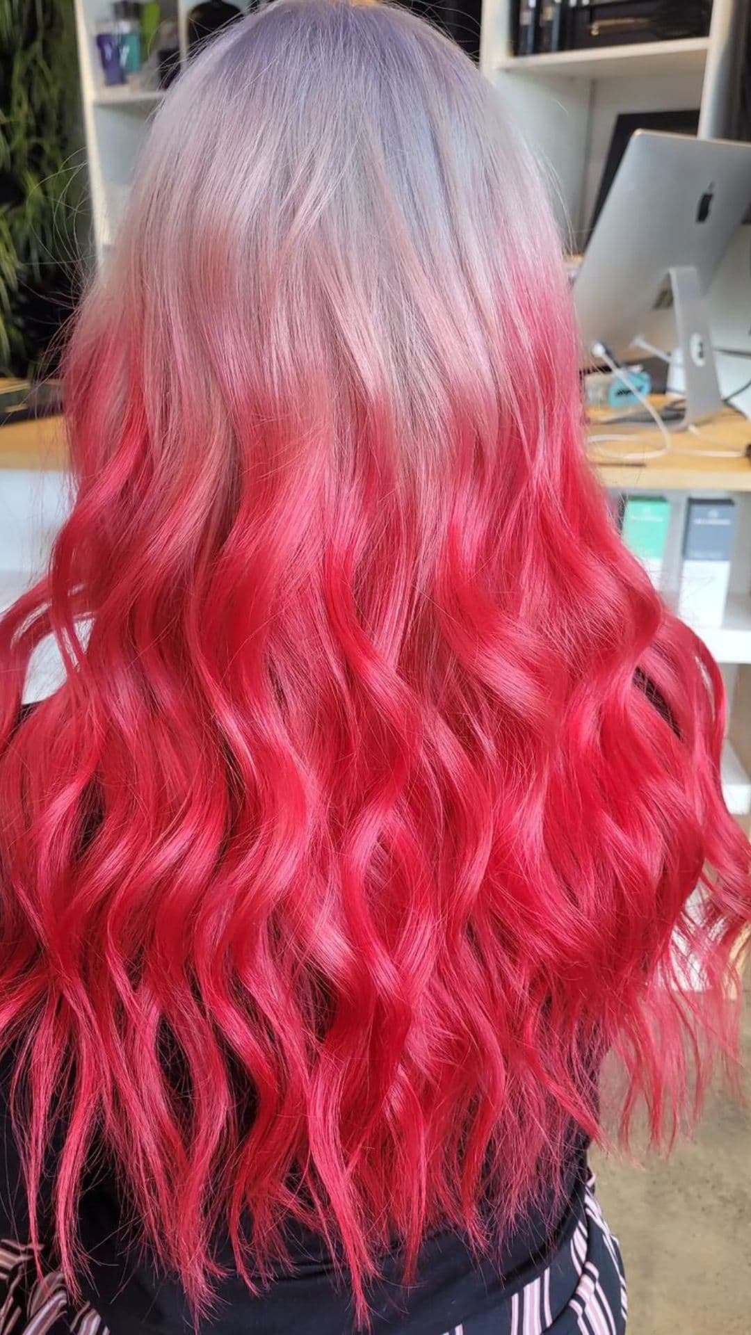 A woman modelling a silver blonde to red ombre.