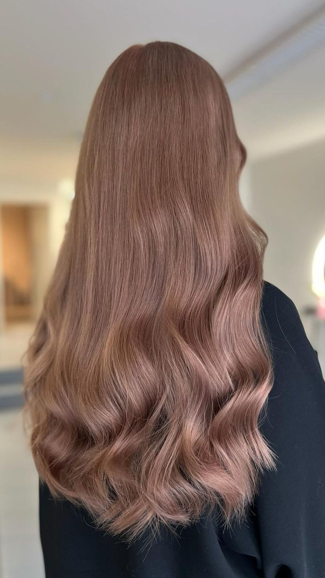 Back view of a person modeling long, wavy Mahogany Blonde hair.