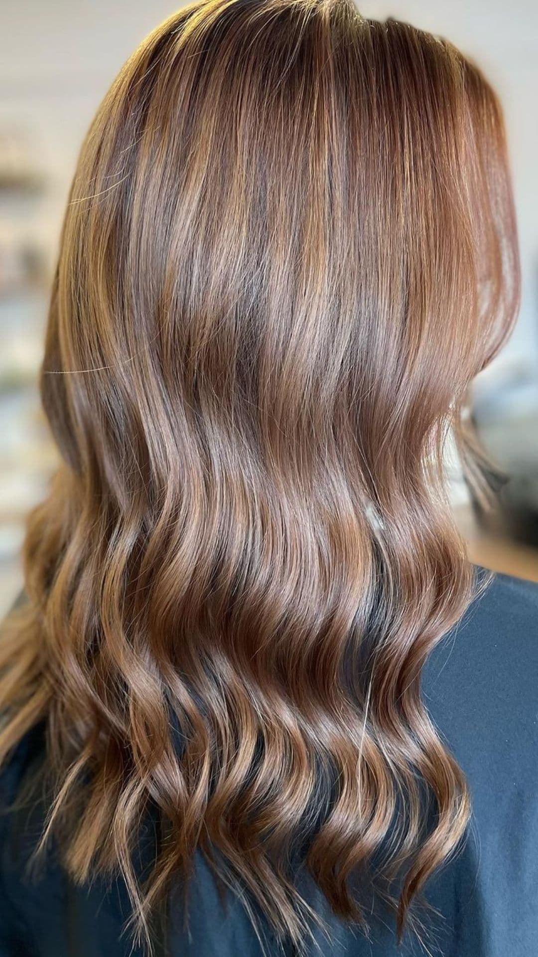 Close-up of wavy hair dyed in Burnished Copper.