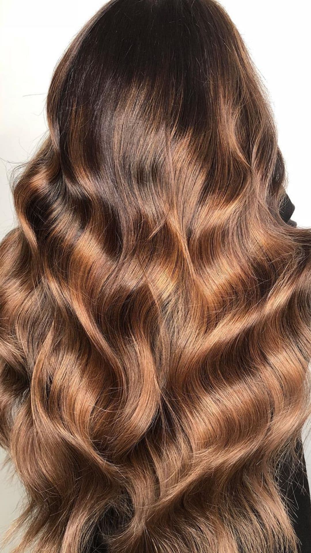 Wavy chestnut ombre hair showcased on a female model.