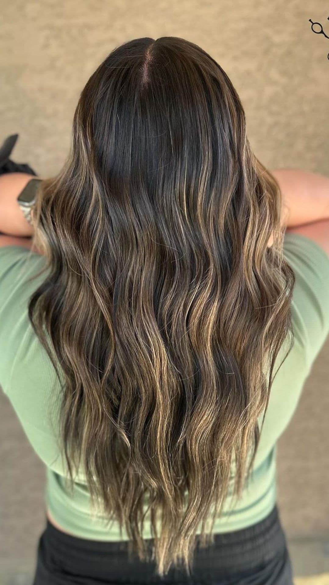 A person showing the back view of their long, wavy hair with Sun-Kissed Babylights.