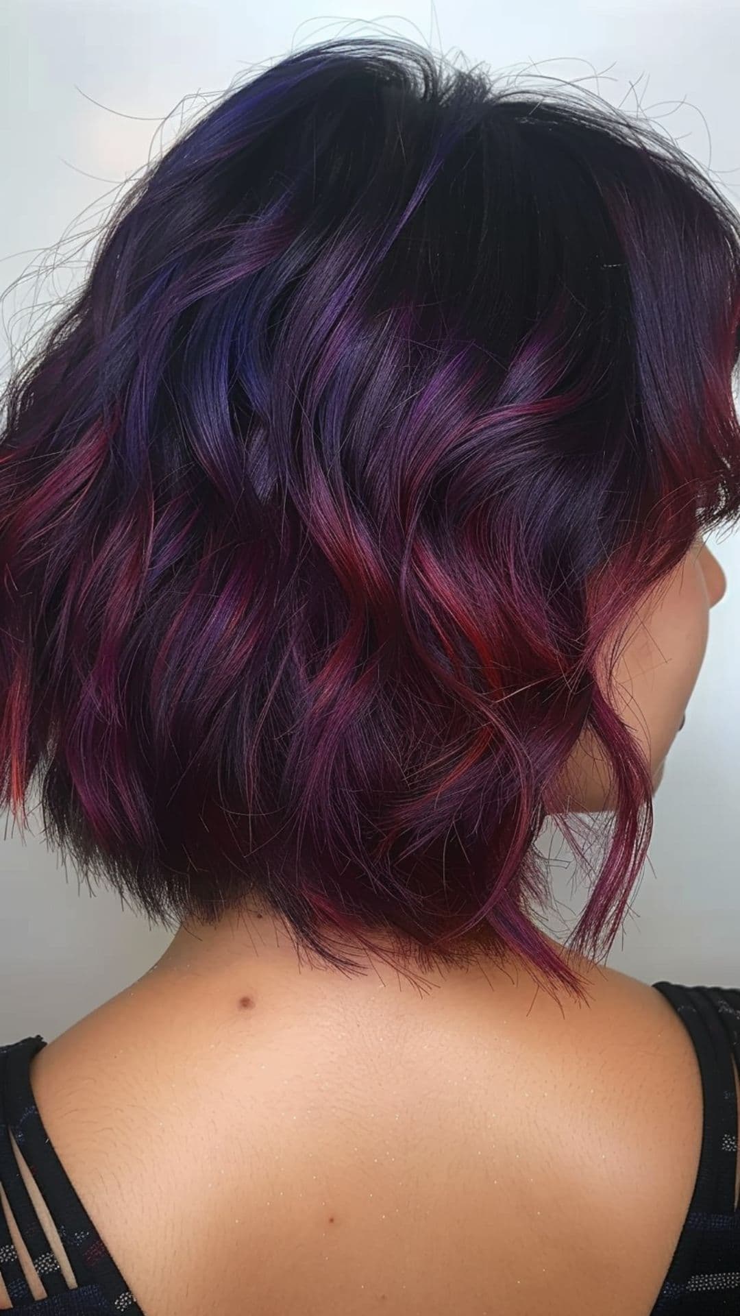 A woman modelling a violet to burgundy ombre hair.