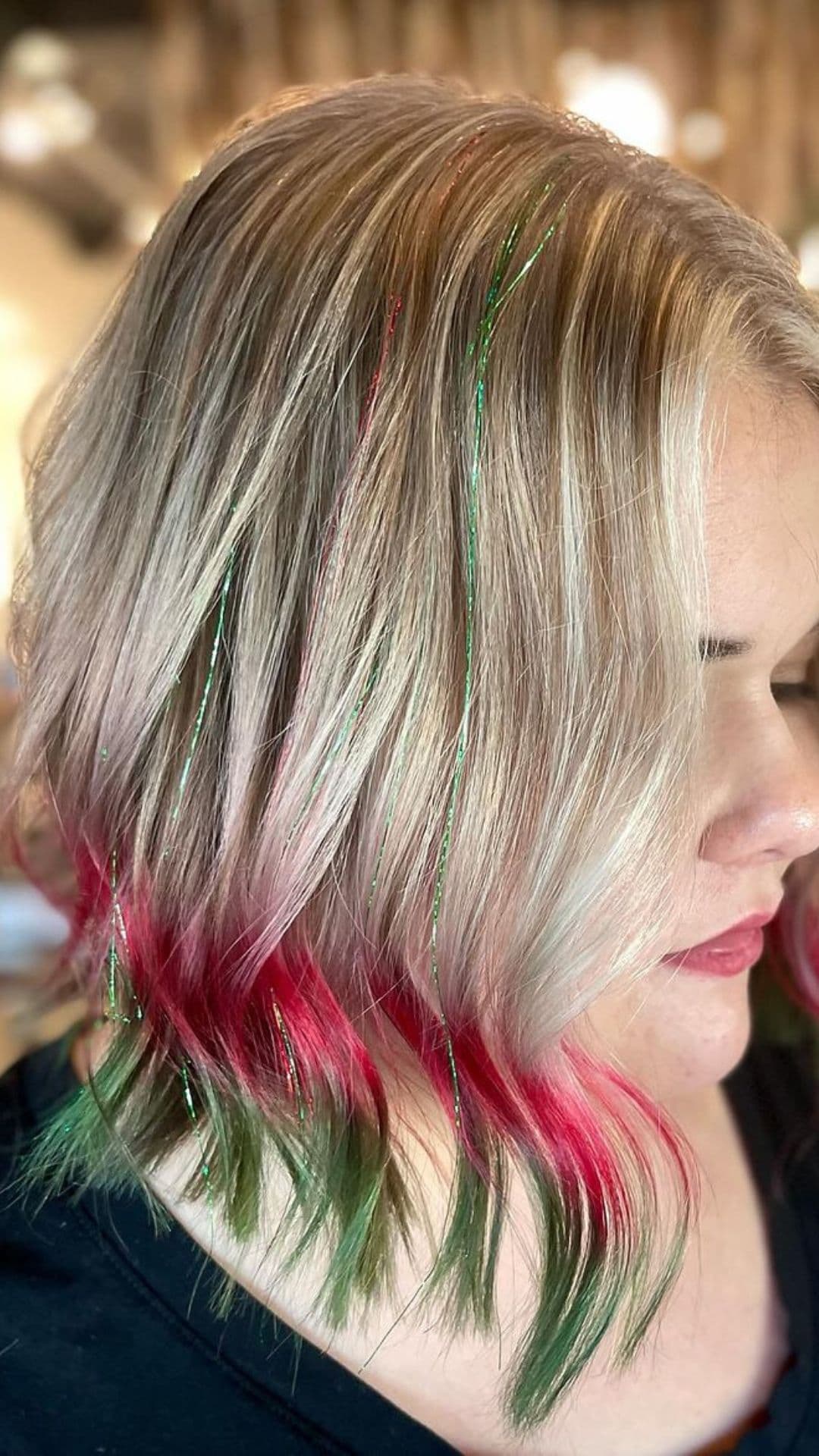 A woman modelling a Wavy Bob with Red and Green Ombre and Tinsel hair.