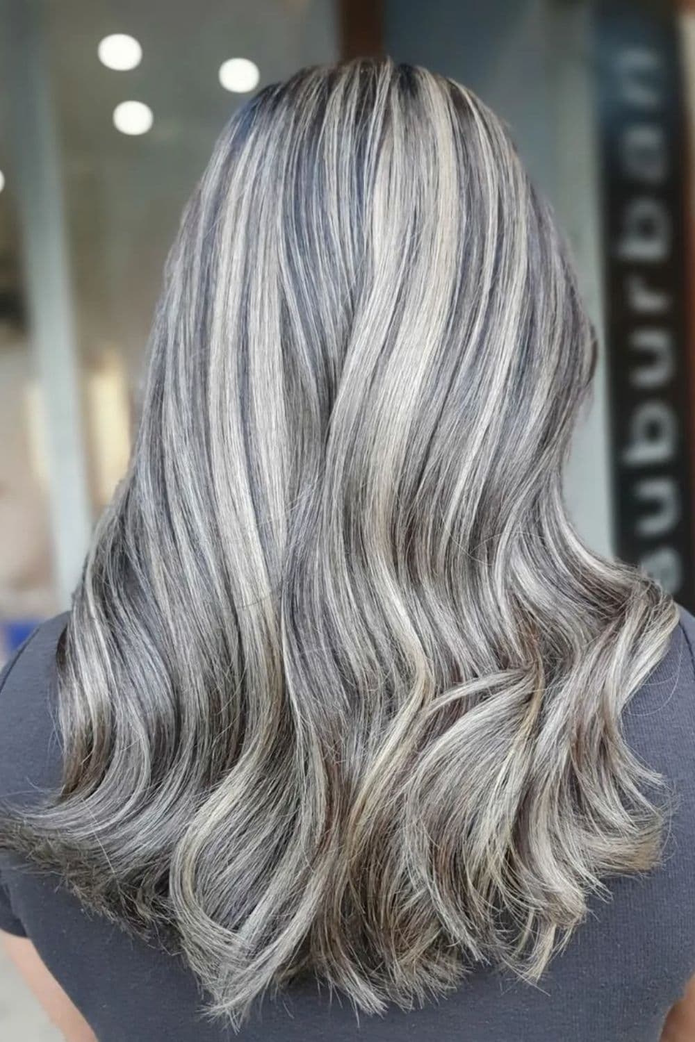 A woman with long ash blonde balayage.