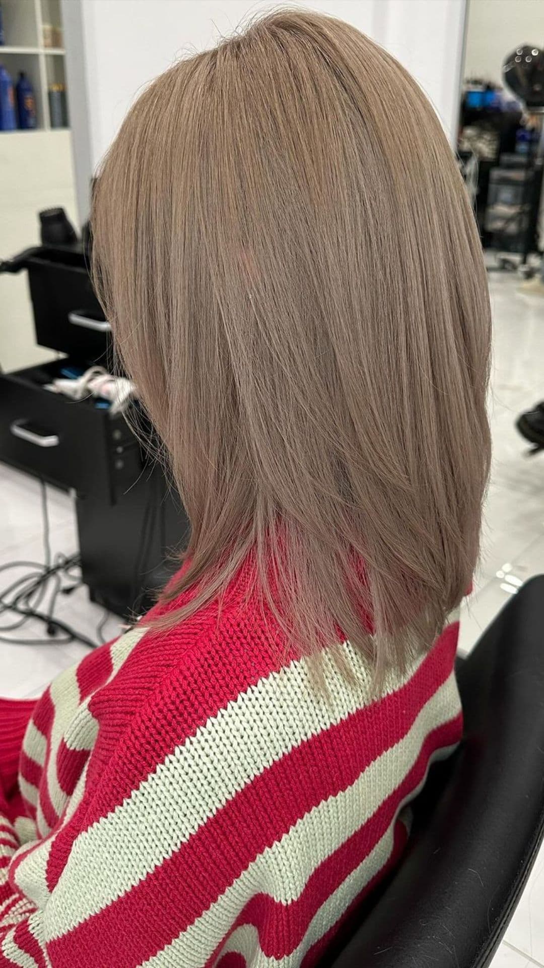 A woman modelling an ash bronde hair color.