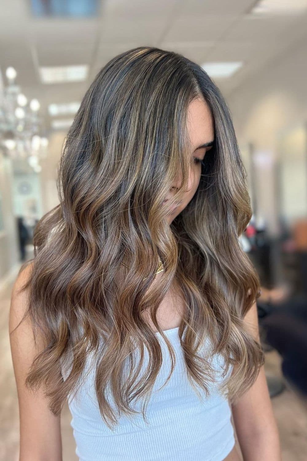 A woman with long ash brown balayage.