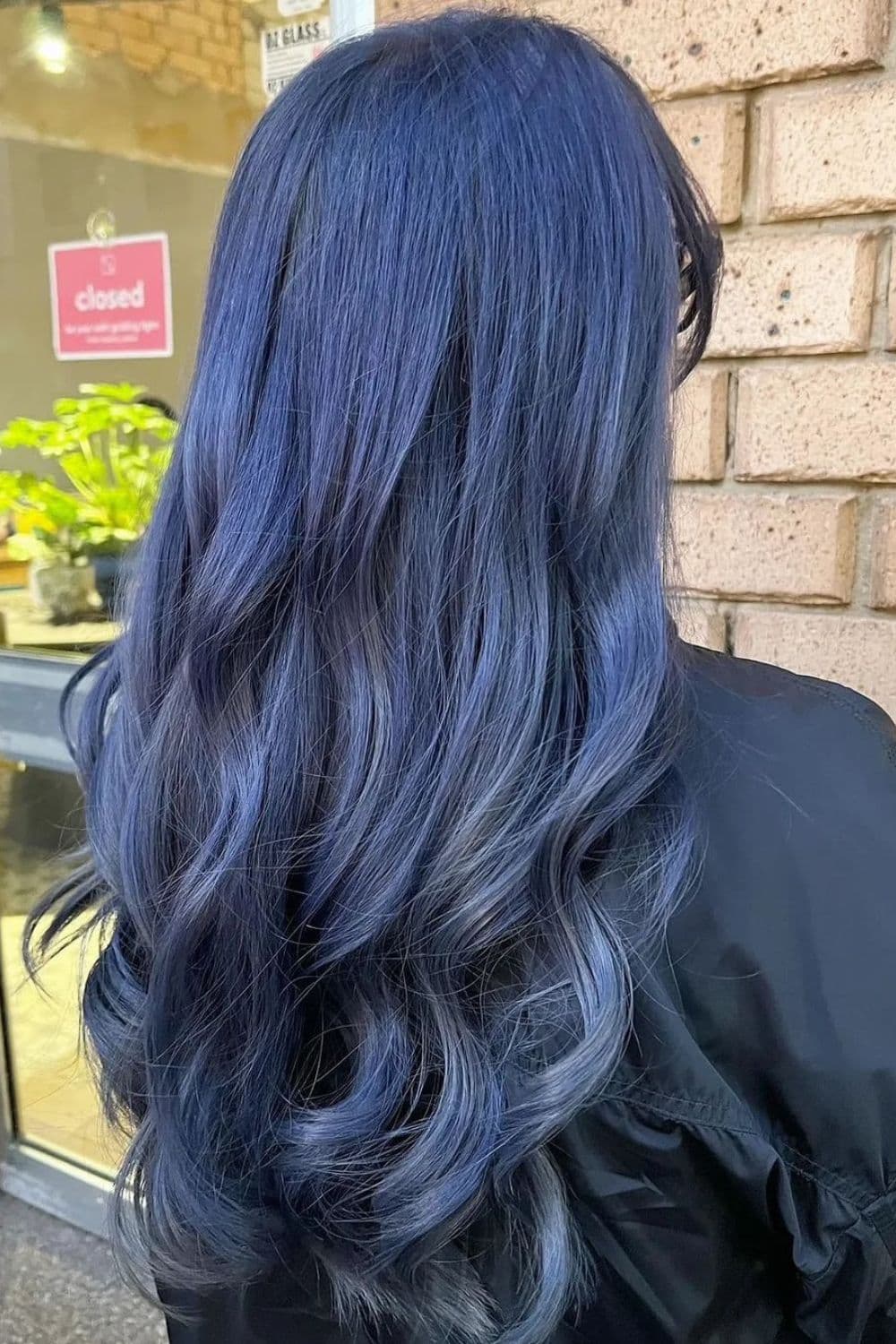 A woman with long wavy bluish silver hair.