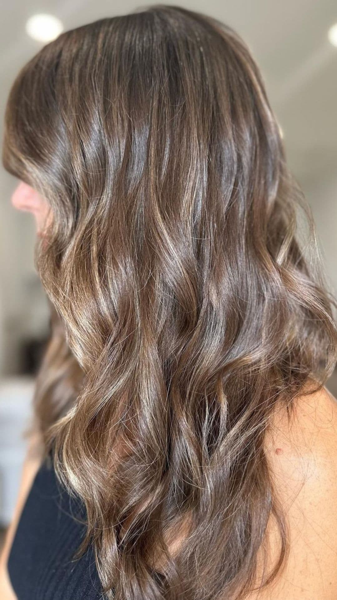 A woman modelling a chestnut highlights hair.