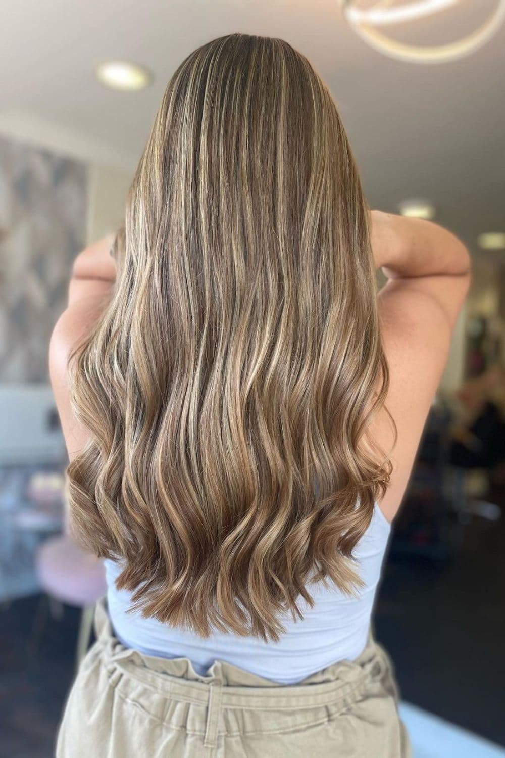 A woman with long wavy creamy blonde balayage.