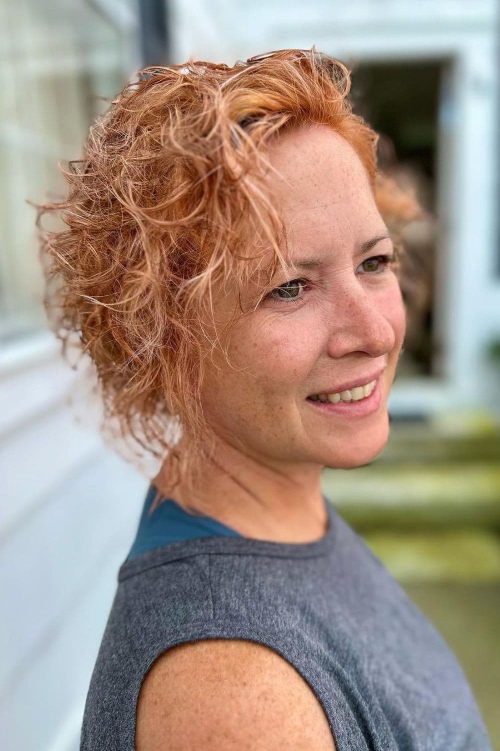 A woman with short curly strawberry blonde hair.