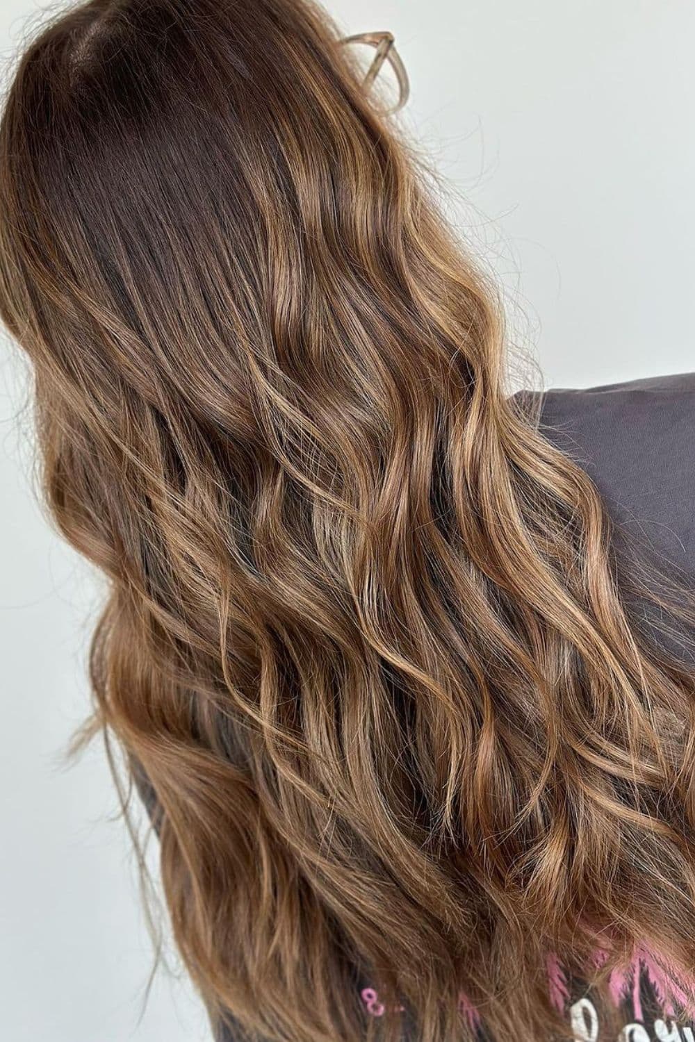 A woman with long wavy dirty blonde balayage.