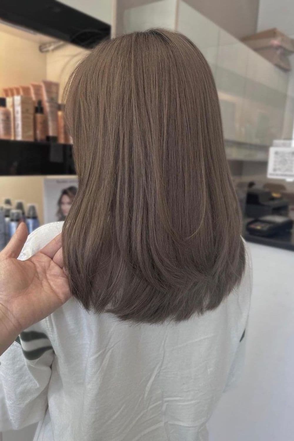 A woman with medium length mushroom brown hair.