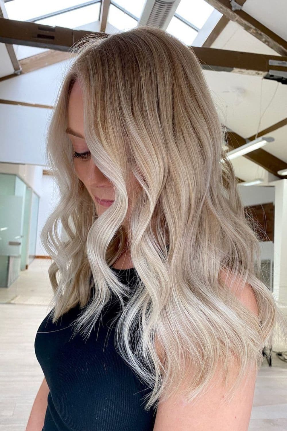 A woman with medium-length wavy platinum blonde balayage.