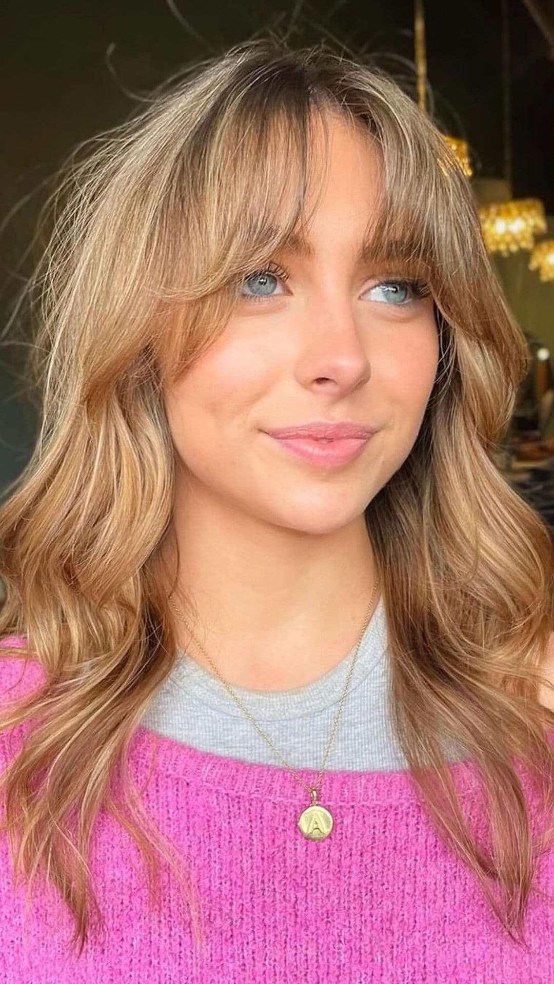 A woman modelling a root shadow and blended light brown hues hairstyle.