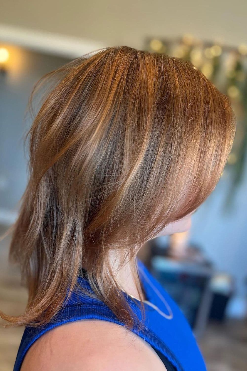 A woman with a strawberry blonde lob with darker underlayers.