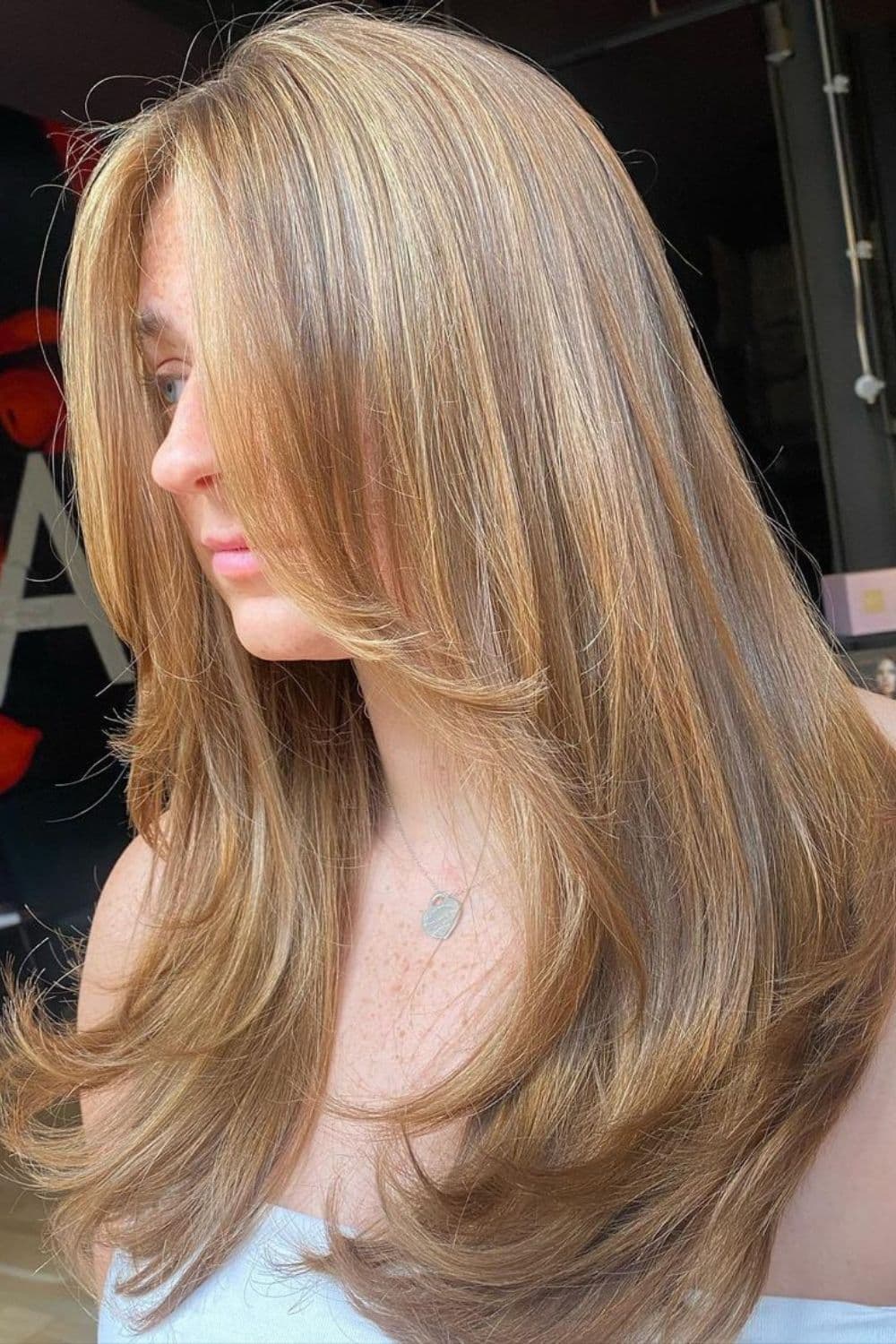 A woman with long strawberry blonde with curtain bangs.