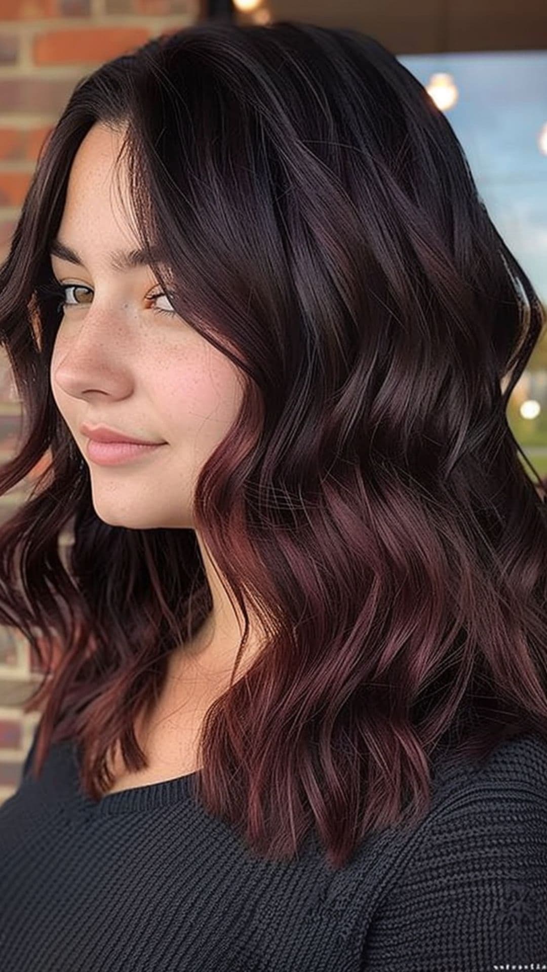 A woman modelling a subtle merlot balayage.