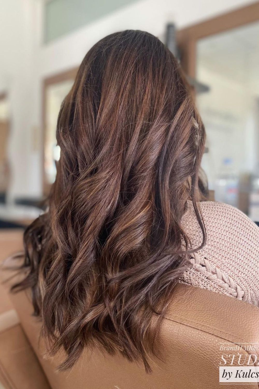 A woman with long toffee brown hair with bog curls.