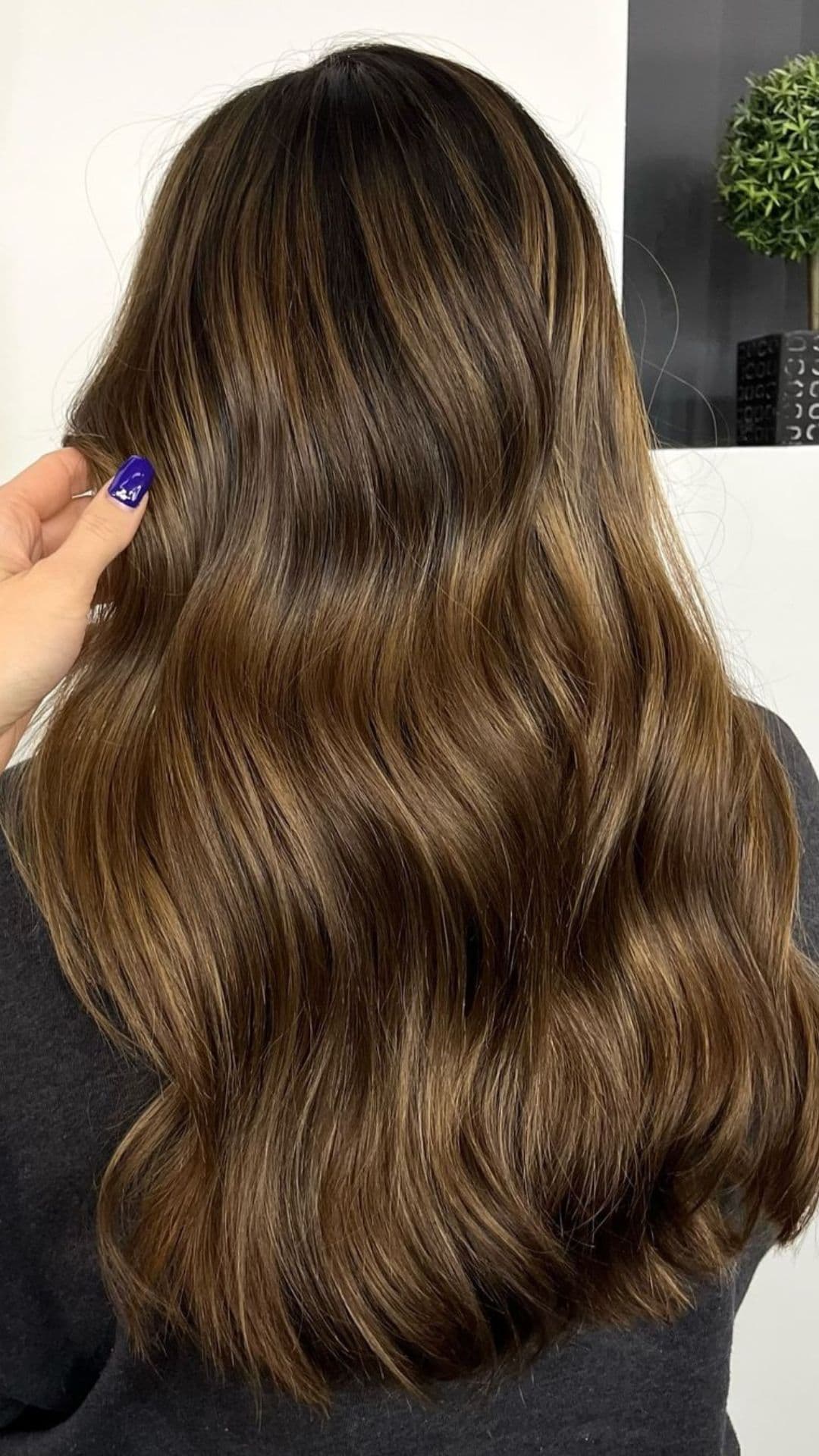 A woman modelling a warm brown balayage.