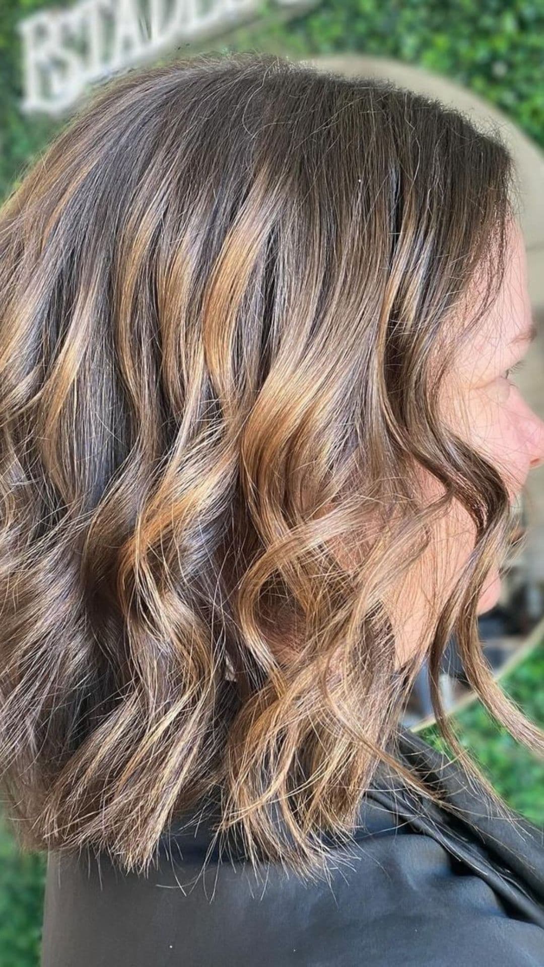 A woman modelling wavy short brown hair with blended highlights.